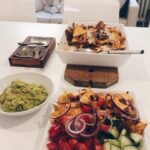 Nachovuoka härkiksestä uunivuoassa, päällä sulanut juusto ja tuoreet kasvikset.