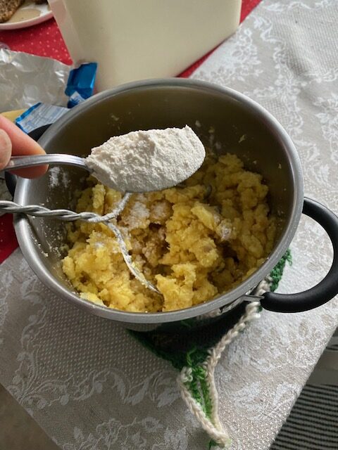 Kattilassa oleva perunasurvos, johon lisätään lusikallinen vehnäjauhoja imellettyä perunalaatikkoa varten.